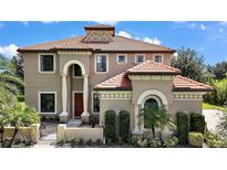 Elegant two-story home featuring a terracotta tile roof and manicured landscaping at 36914 Bee Meadow Ct, Eustis, FL 32736