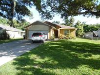 Charming single-story home boasts a well-manicured lawn and inviting curb appeal at 5016 Mcdonald Rd, Zellwood, FL 32798