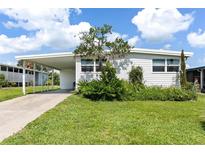 Charming single-story home with a well-maintained lawn and covered parking at 717 W Coach N Four Dr, Leesburg, FL 34748