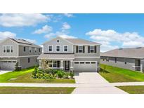 Beautiful two-story home with a well-manicured lawn and an attached two-car garage at 872 Griffon Ave, Lake Alfred, FL 33850