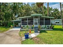 Charming single-story home with a well-manicured lawn, covered carport, and an inviting screened-in porch at 10 Cocos Plumosa Dr, Eustis, FL 32726