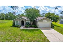Charming single-story home boasts a manicured lawn, mature landscaping, and an attached two-car garage at 10331 Sw 45Th Ave, Ocala, FL 34476