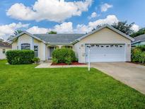 Charming single-story home features a well-maintained lawn, a two-car garage, and lush landscaping at 1107 San Antonio Ln, The Villages, FL 32159