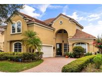 Elegant two-story home with a terra cotta roof and manicured landscaping at 1444 Whitney Isles Dr, Windermere, FL 34786
