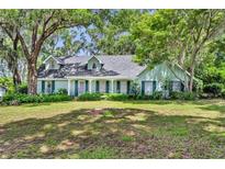 Charming single-Gathering home with lush green lawn and mature trees providing shade at 1841 Normandy Dr, Mount Dora, FL 32757