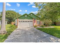 Charming single-Gathering home featuring a manicured lawn, two car garage, and American flag at 2842 Ithaca Ct, Orlando, FL 32826
