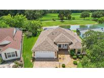 An aerial view of a single story home with a brick driveway, an attached garage, and beautiful landscaping at 2880 Manor Downs, The Villages, FL 32162