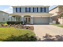Charming home featuring a two-car garage and a beautifully landscaped front yard at 621 Lost Grove Cir, Winter Garden, FL 34787