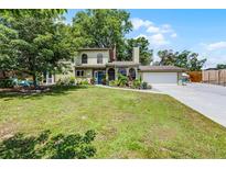 Charming two-story home featuring mature trees, landscaped yard, and attached two car garage at 628 Drew Ave, Clermont, FL 34711