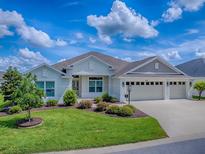 Charming single-story home features a three-car garage, manicured lawn, and lush landscaping at 6295 Danielson Loop, The Villages, FL 32163