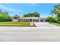 Charming single-story home featuring a brick facade, well-maintained lawn, and an oversized two-car garage at 6829 Bittersweet Ln, Orlando, FL 32819