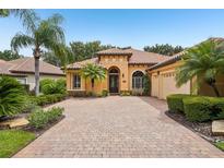 Stunning Mediterranean-style home featuring a tile roof, arched entry, and brick paver driveway at 9433 San Miguel, Howey In The Hills, FL 34737