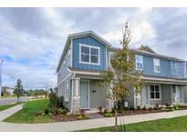 Charming two-story home with blue accents, stone details, manicured landscaping, and beautiful sidewalk at 13108 Serene Glade Rd, Winter Garden, FL 34787
