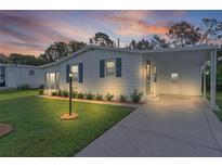 Charming one-story home with fresh white paint, blue shutters, covered parking and a well-maintained lawn at 1421 E Schwartz Blvd, The Villages, FL 32159