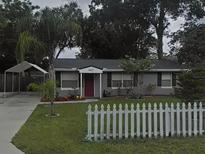 Charming single-story home featuring a well-maintained lawn, picket fence, and covered carport at 1610 Williams Ave, Eustis, FL 32726