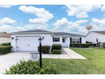 Charming single-story home features a well-manicured lawn and attached garage in a friendly neighborhood at 1654 Blossom Ter, The Villages, FL 32162