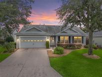 Charming single-story home boasts a well-manicured lawn, inviting curb appeal, and an attached two-car garage at 1889 Union Pl, The Villages, FL 32162
