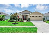 Charming single-story home featuring a manicured lawn and a two-car garage at 26653 Otter Creek Ln, Leesburg, FL 34748