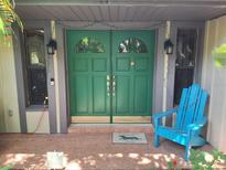 Inviting front entrance featuring a bright green double door and a cheerful blue Adirondack chair at 29205 Old E Ml, Tavares, FL 32778