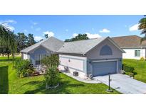 Charming home with a two-car garage, well-manicured lawn, and inviting landscaping, offering great curb appeal at 3601 Mount Hope Loop, Leesburg, FL 34748