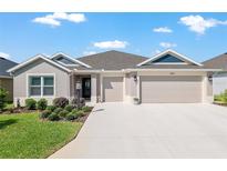 Charming single-story home with manicured lawn, three-car garage and neutral color scheme at 4702 Malone Cir, The Villages, FL 32163