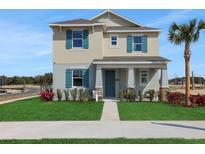 Charming two-story home featuring a well-manicured lawn and eye-catching turquoise shutters at 5177 Blanket Flower St, Apopka, FL 32712