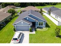 Well-maintained single-story home featuring manicured lawn, a two-car garage, and welcoming curb appeal at 7732 Sloewood Dr, Leesburg, FL 34748
