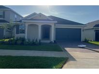 Charming single-story home with a well-maintained lawn and a two-car garage at 2324 Juniper Berry Dr, Minneola, FL 34715