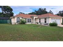 Well-maintained single-story home features a large front yard and an attached two-car garage at 2947 Aldrich St, Eustis, FL 32726