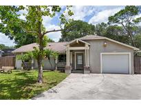 Charming single-story home with a well-maintained lawn, mature trees, and a welcoming entrance at 461 Kee St, Apopka, FL 32712