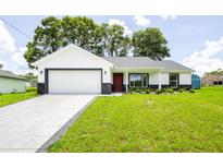 Charming single-story home boasts a well-manicured lawn and a two-car garage at 13050 Ne 7Th Loop, Silver Springs, FL 34488