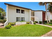 Front view of condo building showcasing landscaping and building features at 1 Tomoka Oaks Blvd # 102, Ormond Beach, FL 32174