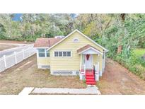 Cute yellow house with red steps and white picket fence, nice yard at 2605 W Silver Springs Blvd, Ocala, FL 34475