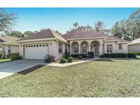 Charming single story home with arched entry, well maintained lawn and two car garage at 11031 Sw 69Th Cir, Ocala, FL 34476