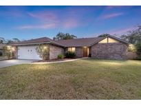 Charming single-story brick home featuring a well-manicured lawn and attached two-car garage at 2922 Se 38Th Pl, Ocala, FL 34480