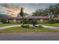 Charming single-story brick home with a circular driveway and professionally landscaped front yard at 906 Crestview Dr, Auburndale, FL 33823