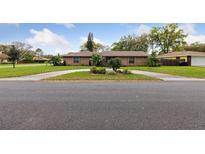 Charming single-story home with well-maintained landscaping and a circular driveway enhancing its curb appeal at 906 Crestview Dr, Auburndale, FL 33823