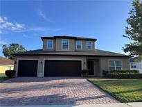 Charming two-story home with a three car garage and a brick paver driveway at 3447 Cypress Grove Dr, Eustis, FL 32736