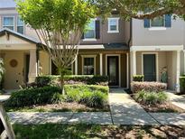 Inviting townhome featuring meticulously landscaped front yard and charming covered entry, creating a welcoming curb appeal at 5108 Caspian St, St Cloud, FL 34771