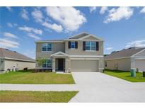 Charming two-story home with a well-manicured lawn and attached two-car garage at 6683 Se 3Rd Loop, Ocala, FL 34472