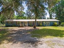 Charming single-story home with a metal roof, inviting porch, and mature trees at 18341 Nw 142Nd Court Rd, Williston, FL 32696
