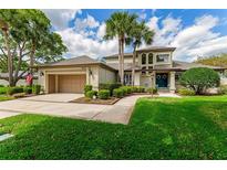 Charming two-story home with mature landscaping, lush green lawn, and an attached two-car garage at 1882 Royal Lytham Ct, Port Orange, FL 32128