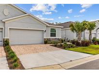 Charming home featuring a neutral exterior, paver driveway, stone accents and fresh landscaping at 5237 Nw 48Th Pl, Ocala, FL 34482