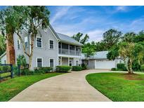 Charming home featuring a metal roof, spacious driveway, two-story porch, and mature landscaping at 20250 Nw 71St Ct, Micanopy, FL 32667