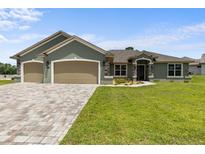 Inviting curb appeal with a three-car garage and well-manicured lawn at 17887 Sw 72Nd Street Rd, Dunnellon, FL 34432