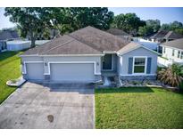 Charming single-story home featuring a three-car garage, well-maintained lawn, and stone accents at 4261 Sw 62Nd Loop, Ocala, FL 34474
