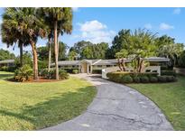 Charming single-story home featuring a long driveway, mature landscaping and inviting curb appeal at 2135 Se 12Th St, Ocala, FL 34471