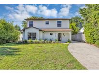 Charming two-story home with a landscaped lawn and a driveway leading to the front entrance at 716 Golfview St, Orlando, FL 32804
