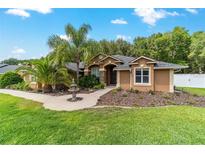 Charming home featuring a well-maintained lawn, decorative fountain, and lush landscaping at 5005 Se 47Th Terrace Rd, Ocala, FL 34480