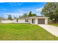 Cozy single-story home with an attached garage, front lawn, and simple landscaping at 680 Nw 67Th Pl, Ocala, FL 34475